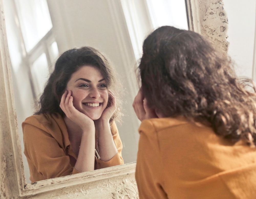 looking happily in the mirror
